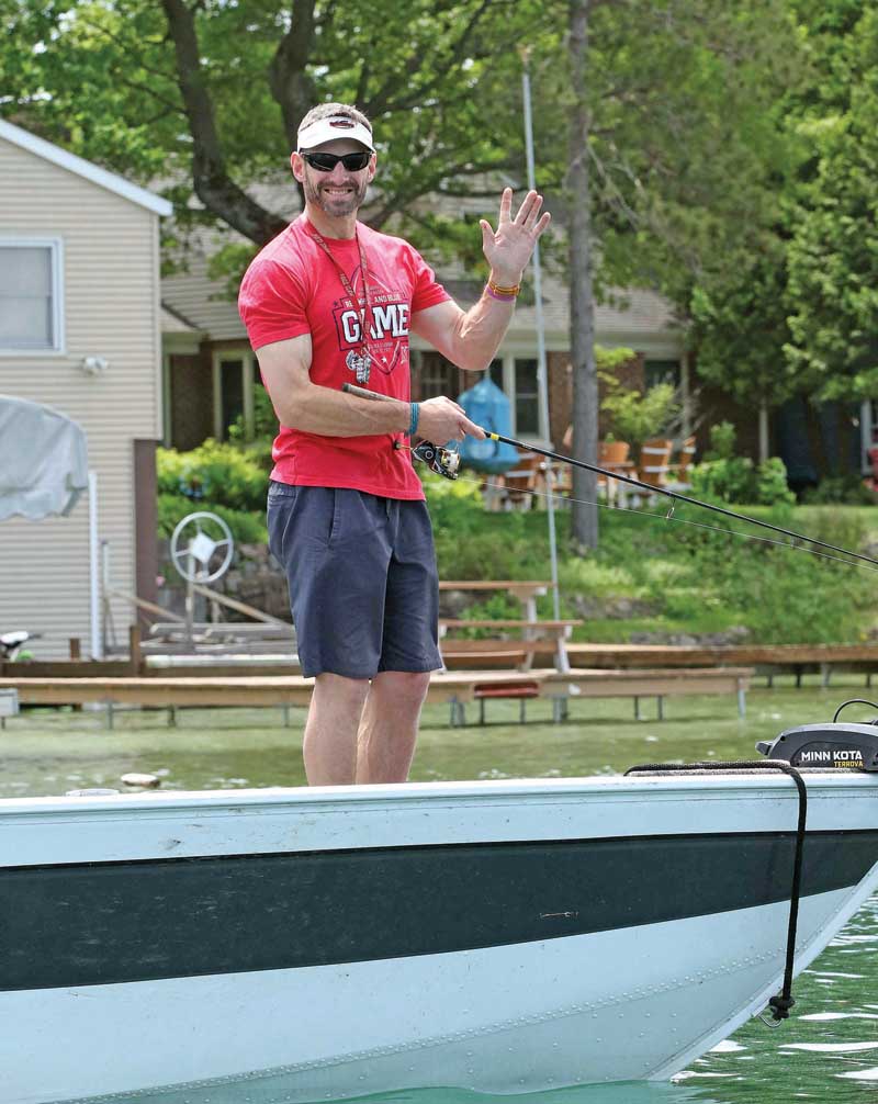 Scott Wendlandt gives a little wave to the photographer while spending the day fishing on Mc Crossen Lake.