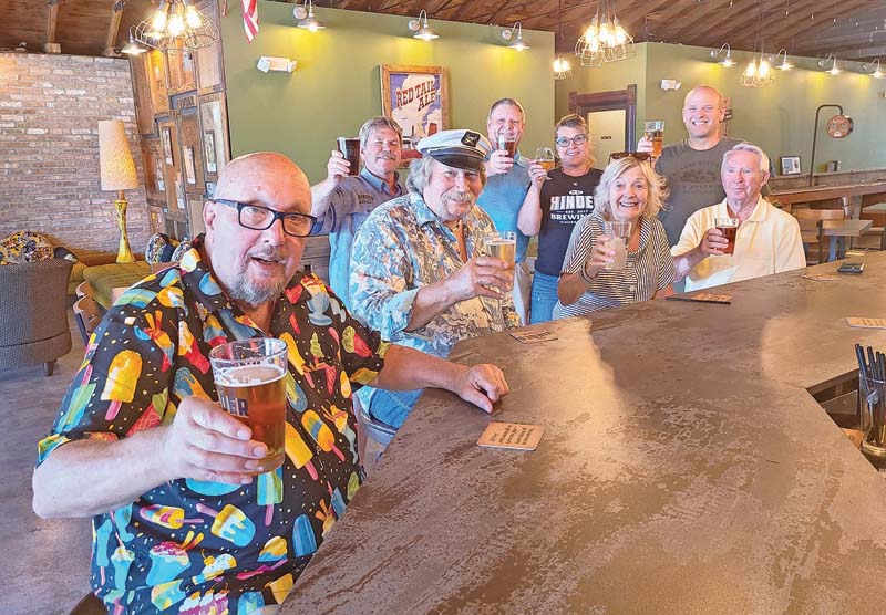 Gary Merrill, Mike Stroik, Fred Beyer, Mitchell Swenson, Jackie Stroik, Kathy Beyer, Paul Cappelle and Eugene Knutson toasting a beer at H. H. Hinder Brewing Company.