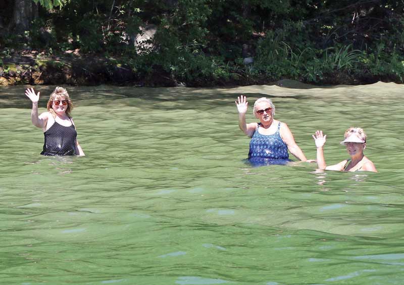 These ladies give a wave to the photographer while cooling off in Rainbow Lake.