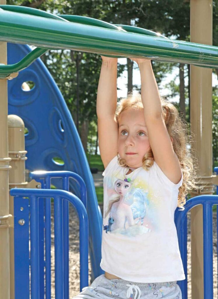5-year-old Margot Barag concentrates as she makes her way across the monkey bars.