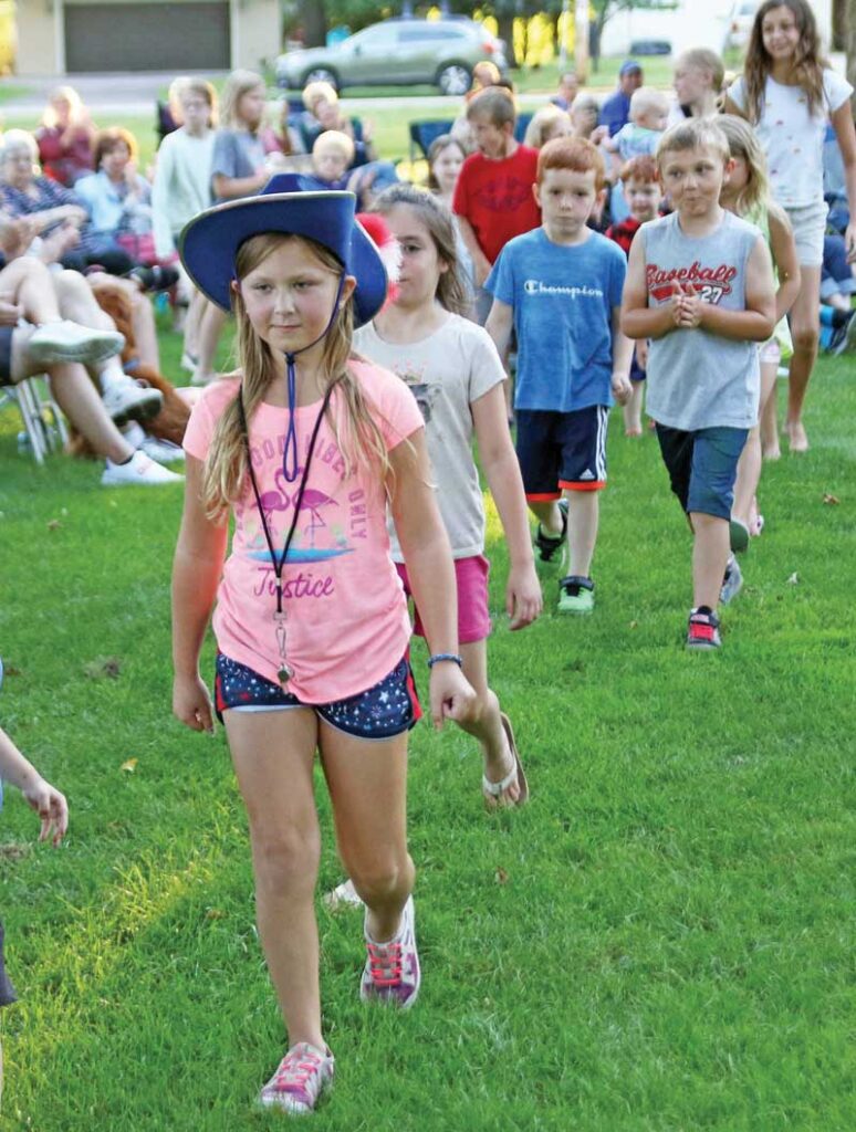 Hayden Kaufmann leads the children’s march during the Waupaca Community Band concert at South Park.