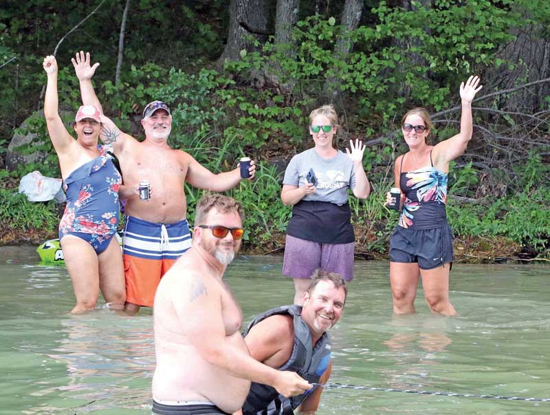 This group gives a wave to the photographer while spending time on Rainbow Lake.