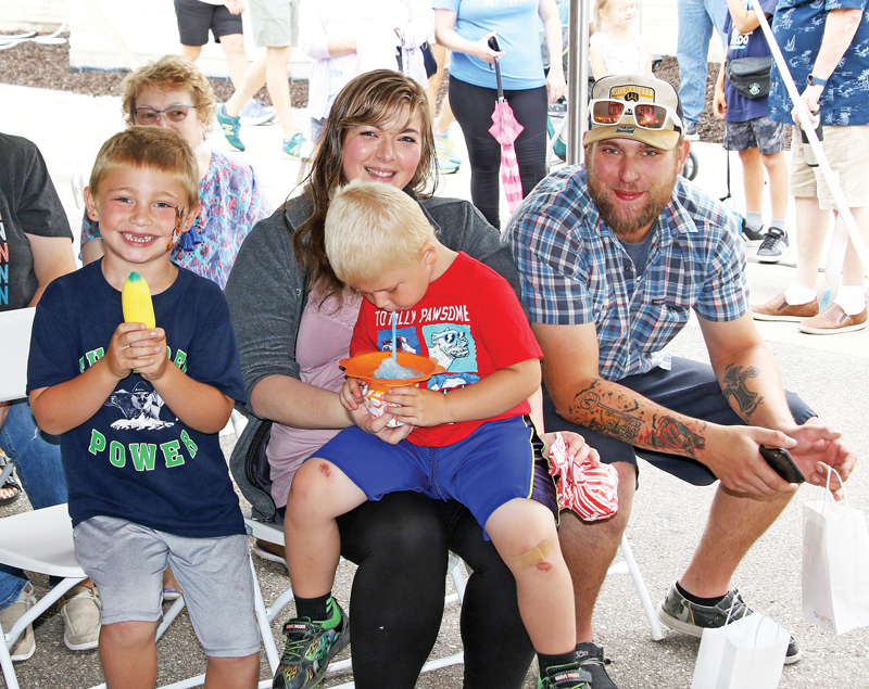 Austin Drapes and Cynthia Nigh, along with Sawyer and Wyatt, enjoyed listening to Tom Pease during the Waupaca Community Arts on the Square.