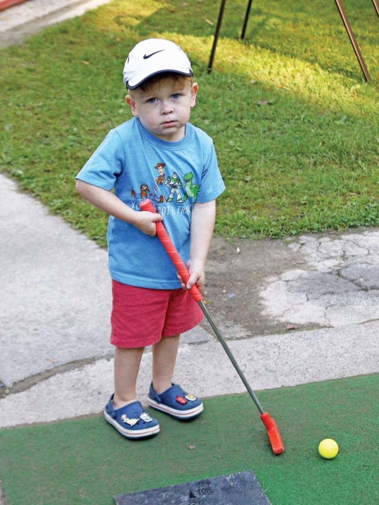 Little Clive Thies, 3, was not sure what to think about playing mini golf.