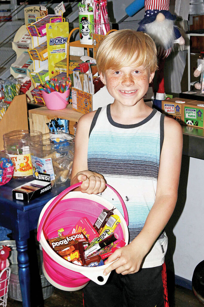 Christopher Tech, 9, was all smiles after filling a bucket with candy at Shindig’s.