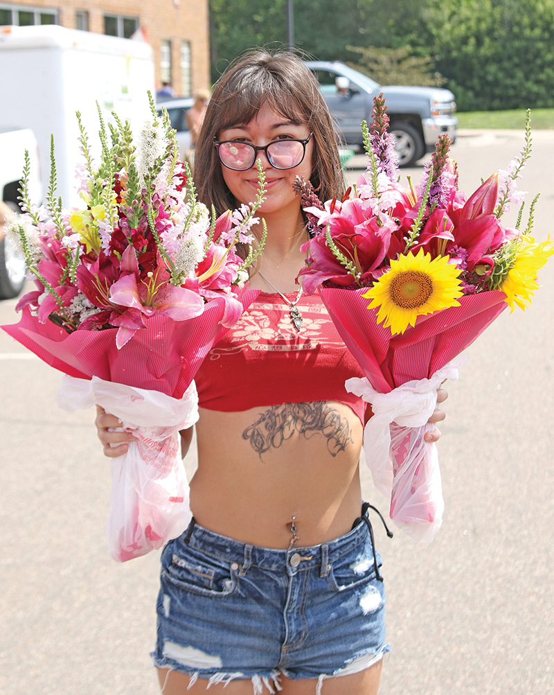 Olivia Patt shows off two beautiful bouquets of flowers that were purchased at the Farmers Market in Waupaca.